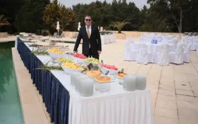 בחליפה ליד שולחן קייטרינג מסודר ליד בריכה - ארגון אירוע שינפלד