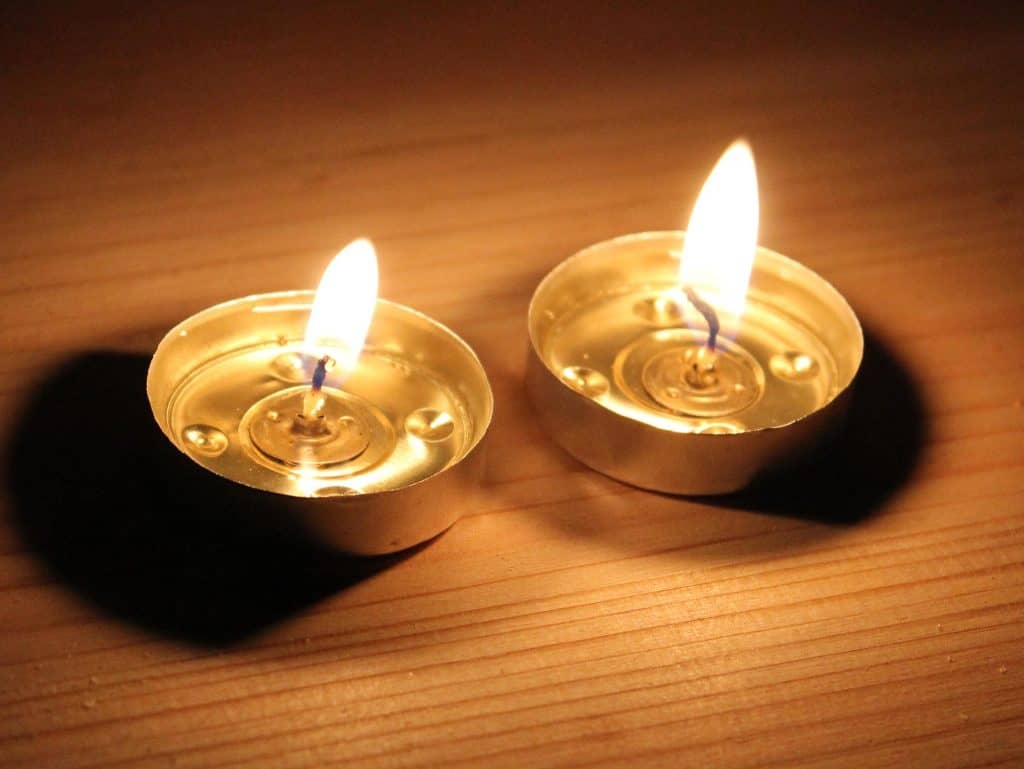 נרות שבת דולקות על משטח עץ - אור חם ורגוע